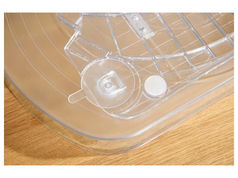 Transparente Kunststoffablage mit Gittermuster und runden Befestigungen auf einer Holzoberfläche.