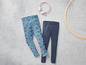 Zwei Paar Leggings, eine mit Kronen-Muster und eine unifarbene dunkelblaue.