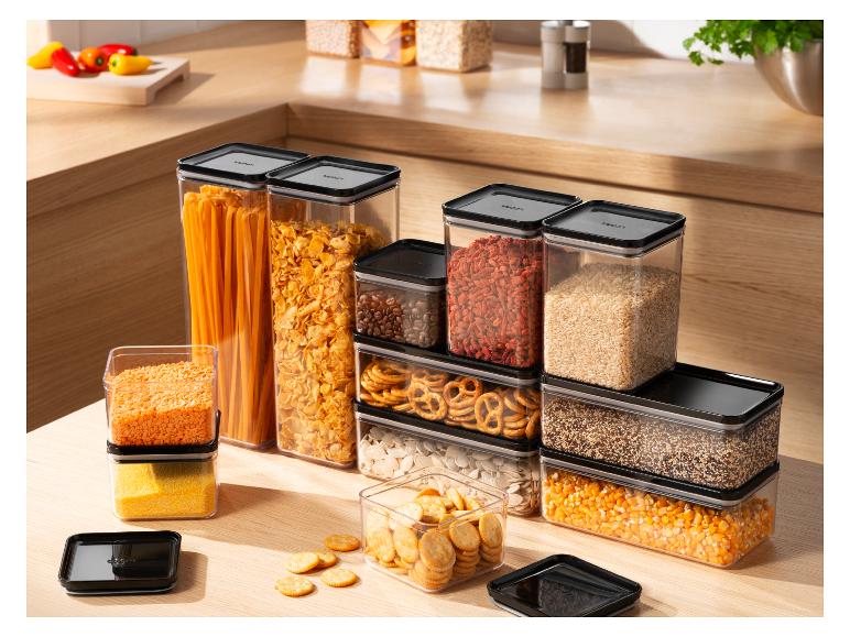 Transparente Vorratsbehälter gefüllt mit Trockenprodukten auf einer Küchenarbeitsplatte.