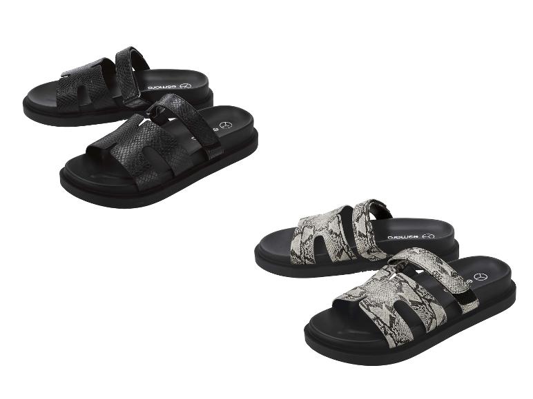 Schwarze und schlangenmuster flache Sandalen mit verstellbaren Riemen.