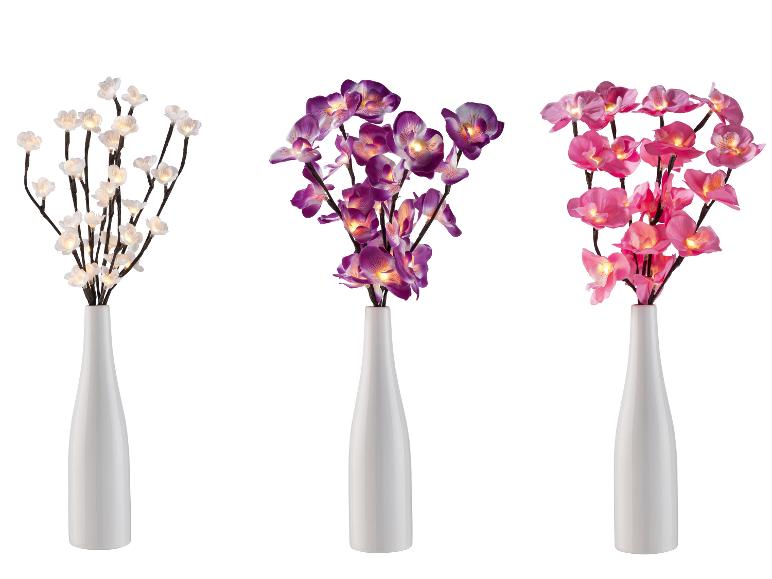 Drei weiße Vasen mit künstlichen Blumen mit Beleuchtung.