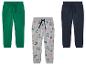 Drei Jungenjogginghosen, eine grüne, eine graue mit Dinosauriern und eine dunkelblaue.