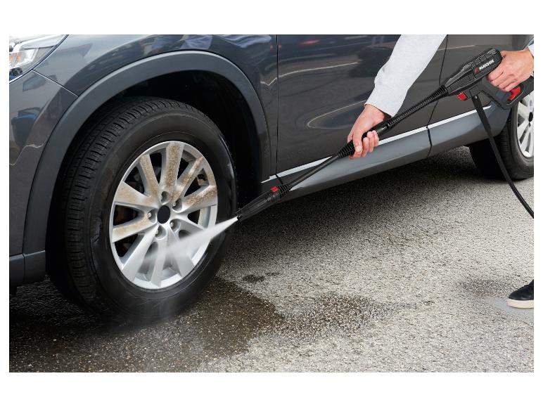 Person wäscht eine schmutzige Autofelge mit einem Hochdruckreiniger.