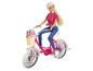 Eine Puppe fährt ein rosafarbenes Fahrrad mit einem Korb