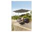 Outdoor-Rattan-Ecksofa-Set mit Kissen, Glastisch und großem grauem Sonnenschirm.