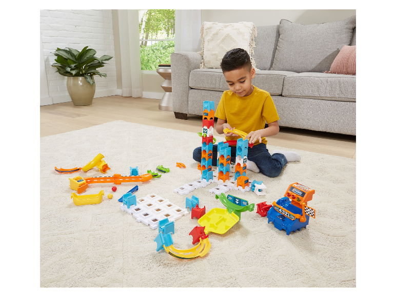 Ein Kind spielt mit einer bunten Murmelbahn.