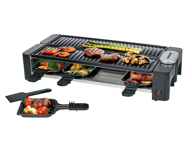 Elektrischer Raclette-Grill mit gegrilltem Gemüse, Fleisch und Meeresfrüchten.