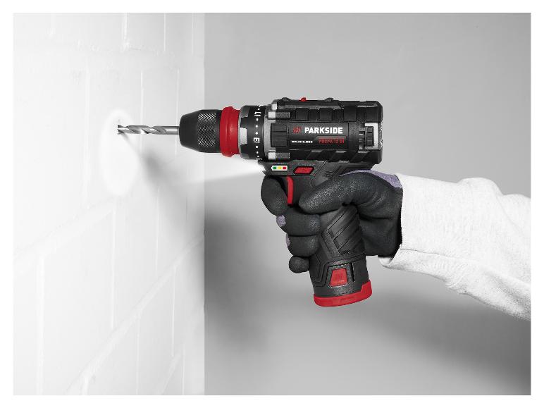 Eine behandschuhte Hand benutzt einen Parkside Bohrer, um in eine weiße Wand zu bohren.