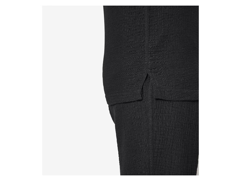 Nahaufnahme von schwarzem strukturiertem Stoff mit Seitenschlitz und Nahtdetail.