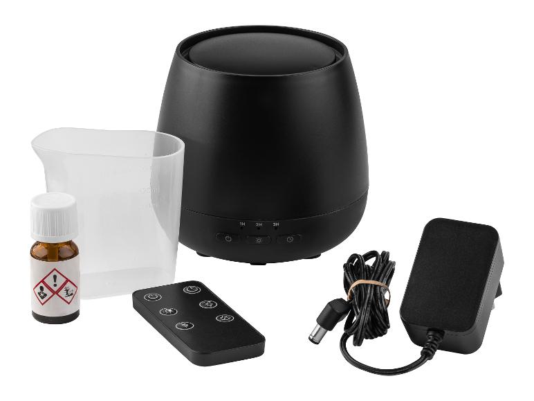 Schwarzer Aroma-Diffusor mit Fernbedienung, Messbecher, ätherischem Öl und Netzteil.