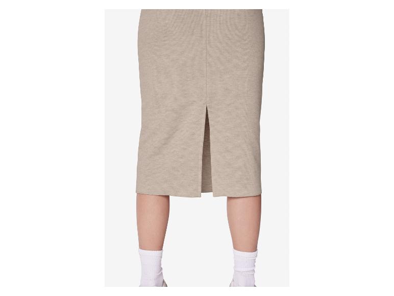 Beiger Midirock mit Rückenschlitz, getragen von einer Person mit weißen Socken und Turnschuhen.