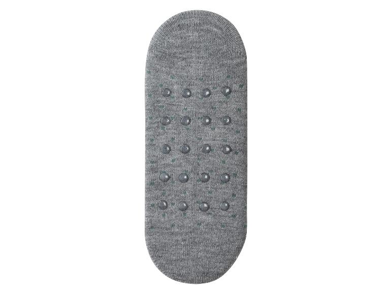 Graue Socken mit Gummiknoppen auf der Sohle.