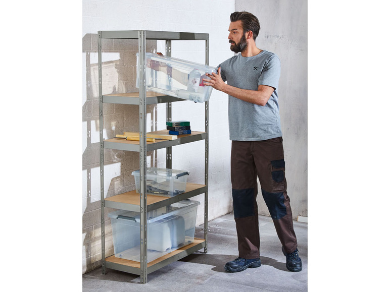 Ein Mann platziert eine durchsichtige Aufbewahrungsbox auf einem Metallregal.
