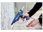 Person verwendet eine blaue Rapid PRO EG340 Heißklebepistole, um ein Kabel an einer Wand zu befestigen.