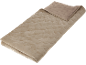 Gefaltete beige Steppdecke mit Muster, teilweise geöffnet, um die Rückseite zu zeigen.