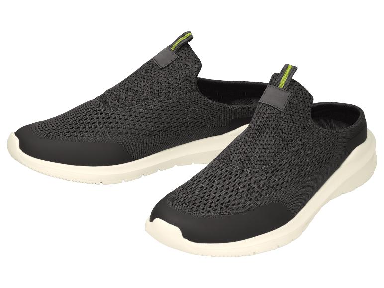 Ein Paar schwarze Slip-on-Sportschuhe mit grünen Akzenten und weißen Sohlen.