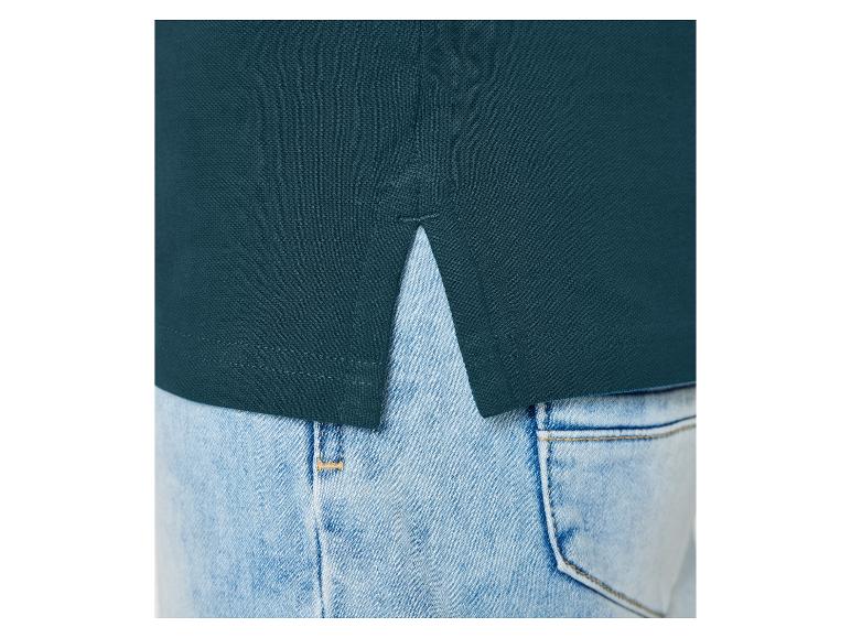 Dunkelgrünes Polohemd und Jeans.