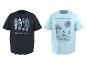 Zwei kurzärmelige T-Shirts: ein dunkles mit Surfbrettern und „GOLDEN HOUR“ und ein hellblaues mit einem Surfer, Palme und „RIDE THE WAVES CALIFORNIA“.