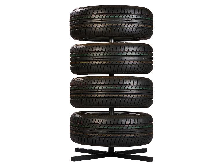 Vier Autoreifen vertikal auf einem schwarzen Ständer gestapelt.