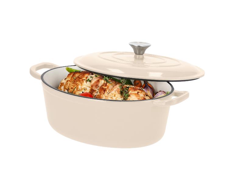 Beiger ovaler Gusseisentopf mit Deckel, gefüllt mit gebratenem Fleisch und Gemüse.