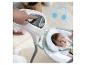 Hand passt Babyschaukel-Einstellungen an, mit Baby in der Schaukel und Musiknoten an der Wand.