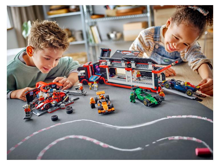 Zwei Kinder spielen mit LEGO Speed Champions Sets, darunter ein Transporter und Rennwagen.