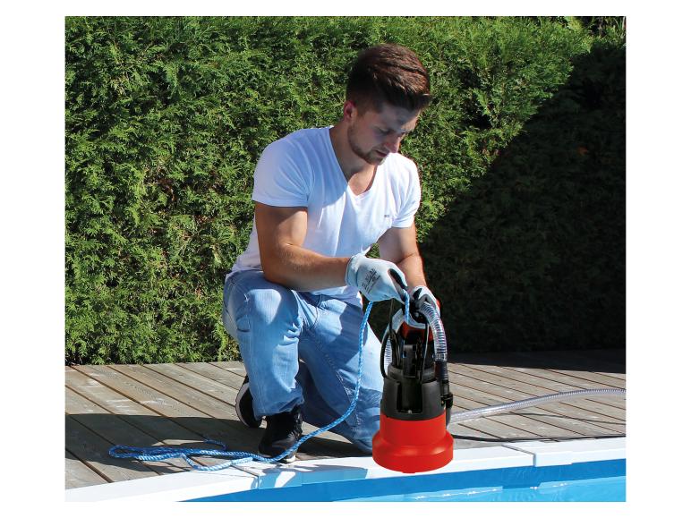 Mann bereitet eine Tauchpumpe für den Einsatz am Pool vor.