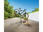 E-Bike auf einem Montageständer mit Werkzeugen auf einem Holzschemel.