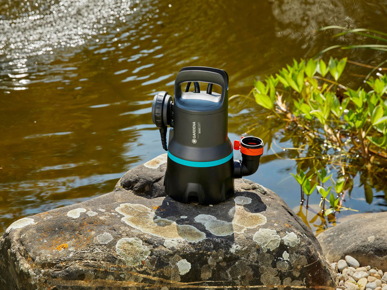 Eine Gardena Teichpumpe auf einem Stein am Teich.