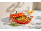 Eintopf mit Fleisch und Kürbis in einem kürbisförmigen Topf, daneben ein Kürbisstück.