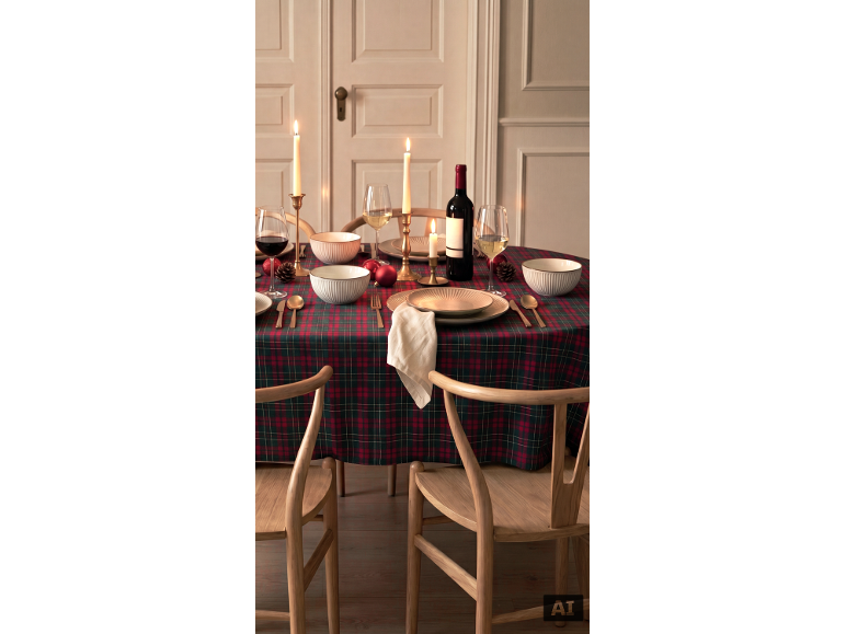 Festlich gedeckter Tisch mit karierter Tischdecke, Wein, Kerzen und Geschirr.