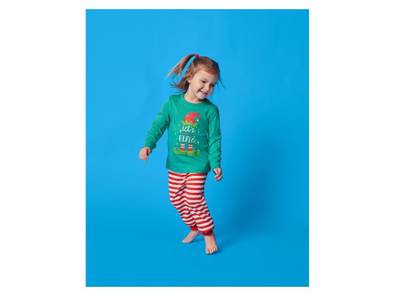 Mädchen in grünem und rot gestreiftem Pyjama mit Elfenaufdruck.