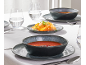 Gedeckter Tisch mit dunklen Suppenschalen, Tellern und Wassergläsern, mit Karottenbeilagen.