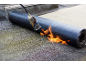 Dachbahnrolle wird mit Brenner verlegt, Flammen erzeugend.