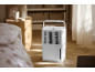 Weißer Luftentfeuchter mit Griff auf Holzboden in einem Schlafzimmer