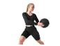 Frau in schwarzer Sportkleidung hält einen schwarzen Medizinball.