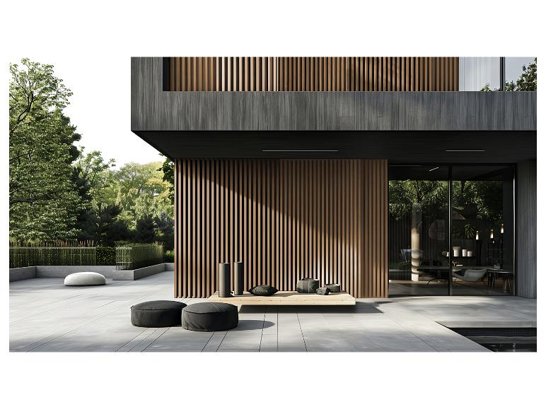 Modernes Haus mit Holzlamellen, Außenterrasse mit Sitzsäcken und grünen Bäumen.