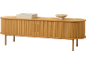 Helles Holz Sideboard mit Rolltüren, Büchern und dekorativer Schale.