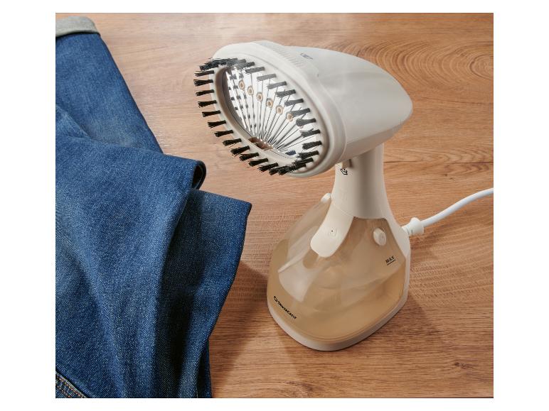 Ein weißer Handdampfglätter mit Bürste, neben einer blauen Jeans.