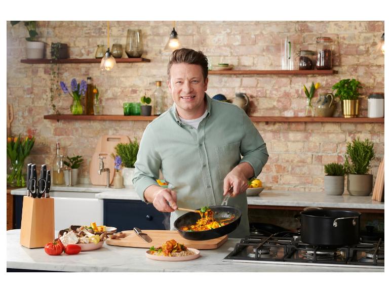 Jamie Oliver bereitet Curry in einer Pfanne und einem Topf zu.