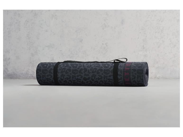 Eine zusammengerollte Yogamatte mit Leopardenmuster und einem schwarzen Band
