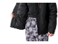 Person in schwarzer Skijacke und gemusterter Skihose.