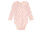 Ein rosa Baby-Body mit roten Herzen von Lupilu.