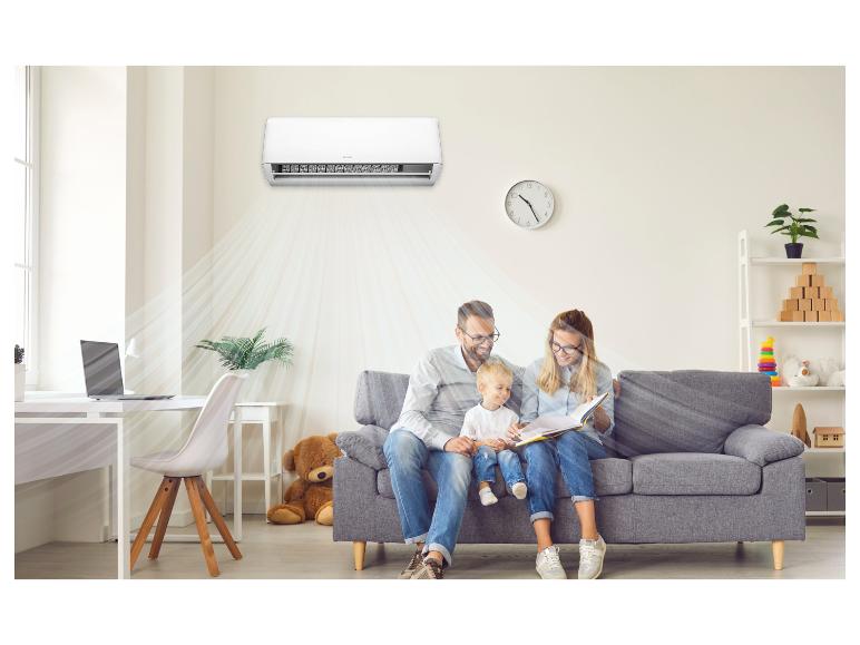 Familie liest auf dem Sofa, mit Klimaanlage, die den Raum kühlt.