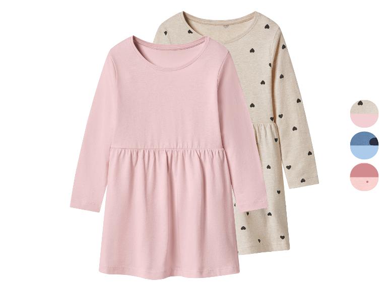 Mädchenkleider mit langen Ärmeln, einfarbig rosa und beige mit schwarzen Herzen.