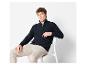 Mann trägt einen dunkelblauen Pullover mit Halbreißverschluss und beige Hose.