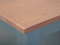 Eine Holztischplatte mit einer hellblauen Unterseite.