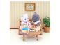 Sylvanian Families Katzenfiguren auf Sofa mit Büchern und Blumenbild.