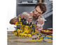 Ein Mann baut einen gelben LEGO Technic Bulldozer.