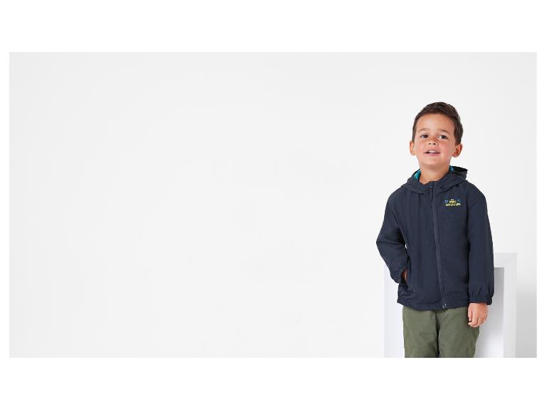 Ein Junge trägt eine blaue Jacke mit dem Schriftzug 'The Big Wood Adventure'.